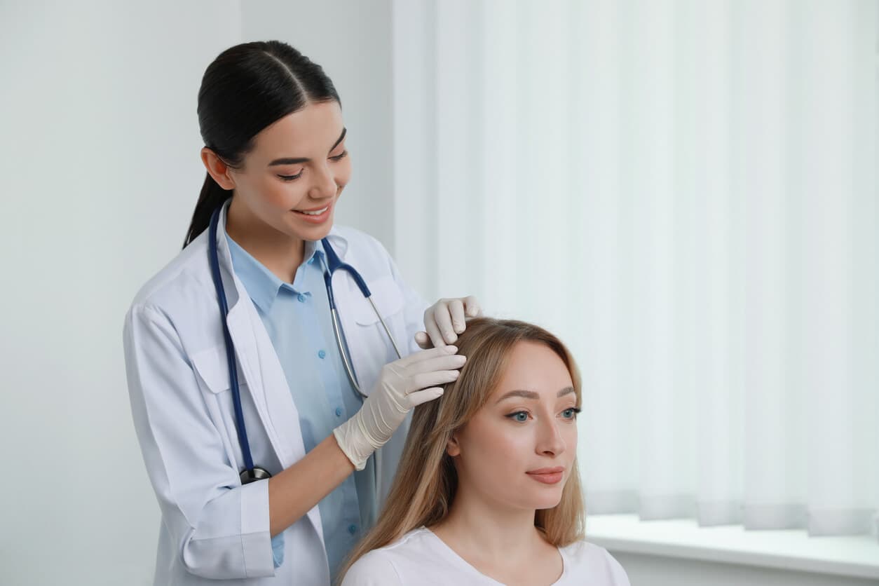 Paciente do sexo feminino durante consulta com uma profissional de tricologia antes do transplante capilar