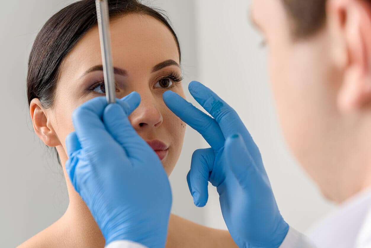 Médica avalia paciente com suspeita de desvio de septo, examinando a estrutura nasal para verificar a necessidade de correção cirúrgica.