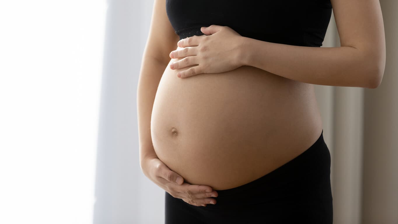 Close na barriga de uma mulher grávida, com vários meses de gestação